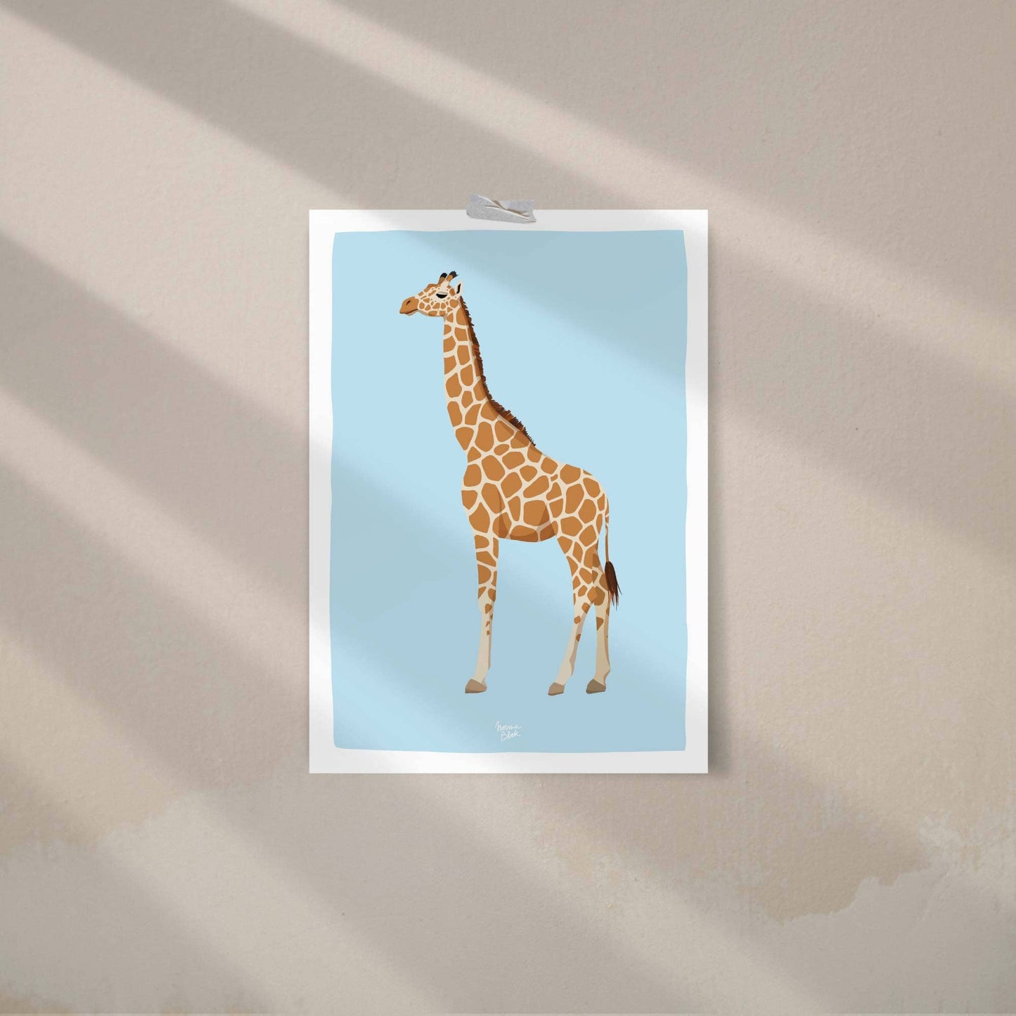 A reticulated giraffe art print attached to a wall with colorful decorative washi tape. This casual, creative display demonstrates a trendy and minimalist way to decorate a home office or bedroom, perfect for those seeking modern, frame-free wall art inspiration.