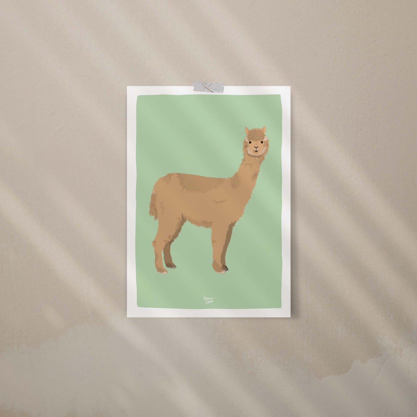 An alpaca art print attached to a beige wall using colorful decorative washi tape. This casual, trendy display is perfect for a relaxed office or bedroom, offering a creative, frame-free way to style your space with modern wall art.