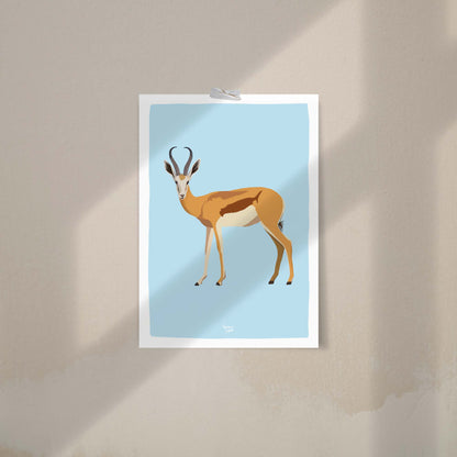 An antelope art print attached to a neutral beige wall using decorative washi tape. This casual, frame-free hanging method highlights the print's versatility and is a trendy way to decorate a creative studio or a relaxed bedroom space.