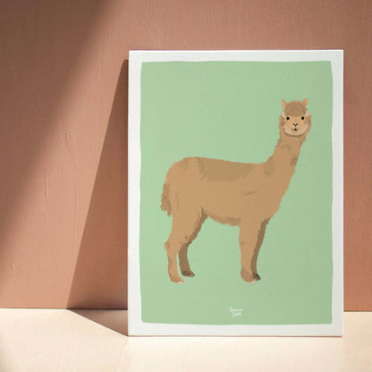 The alpaca art print elegantly leaning against a deep brown wall on a neutral beige floor. This interior styling photo shows how the warm earth tones of the alpaca illustration harmonize with a sophisticated, earthy home decor palette.