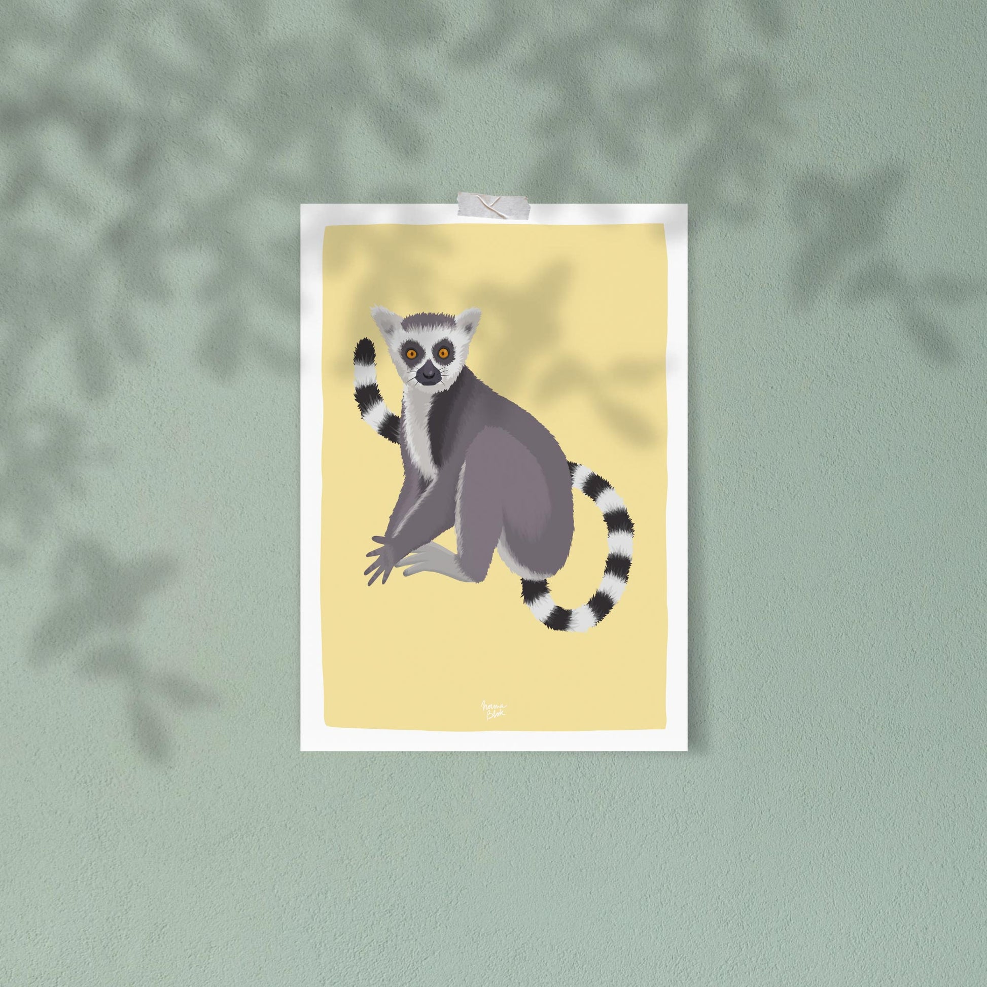 A ring-tailed lemur art print attached to a vibrant green wall using decorative tape. This casual, trendy display focuses on the striking color harmony between the yellow background of the illustration and the green wall, perfect for a creative and relaxed home office style.