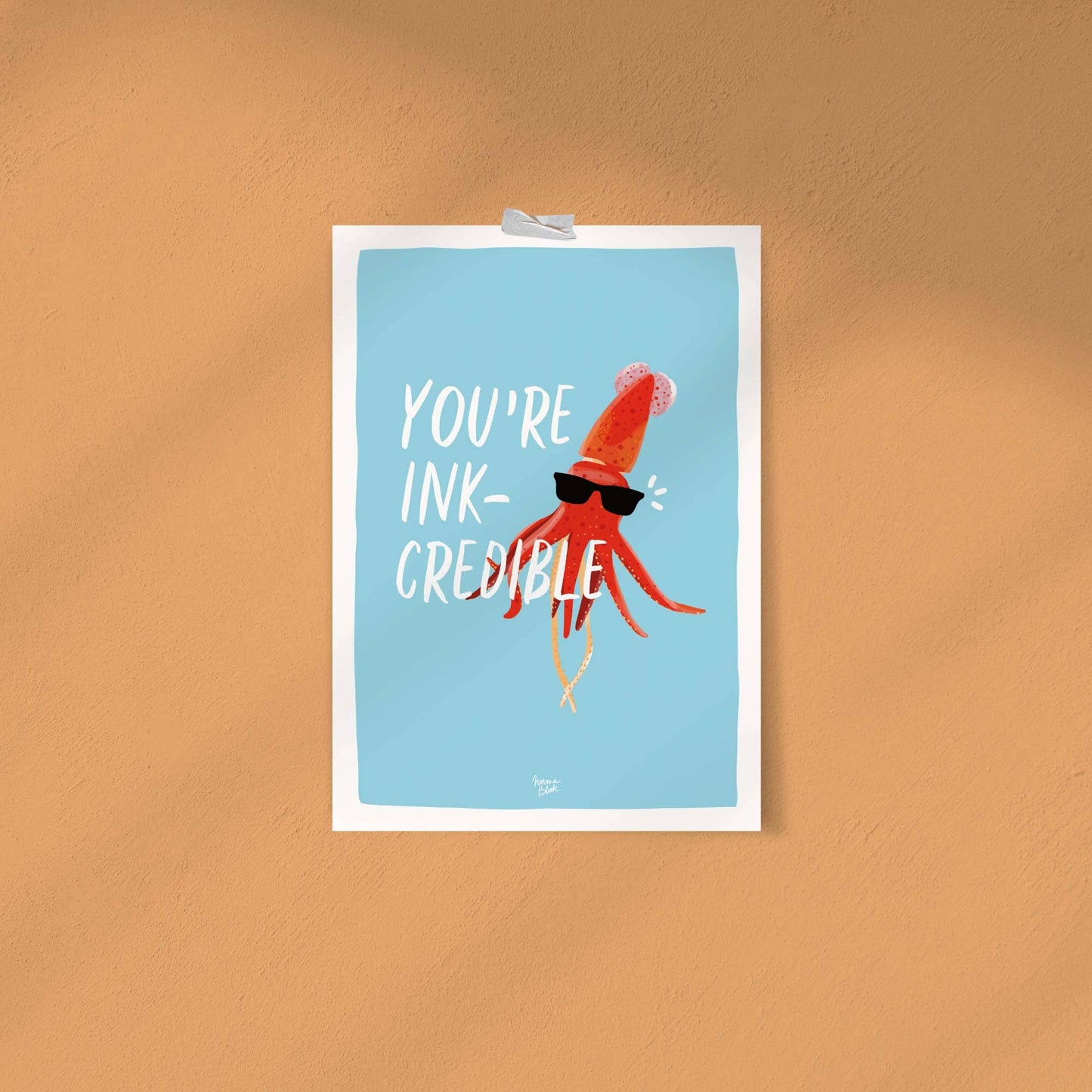 The funny digital squid illustration with sunglasses attached directly to a solid, vibrant orange wall using simple, colorful strips of washi tape. This shot demonstrates a casual, budget-friendly, and modern way to style the art print without using a traditional frame.