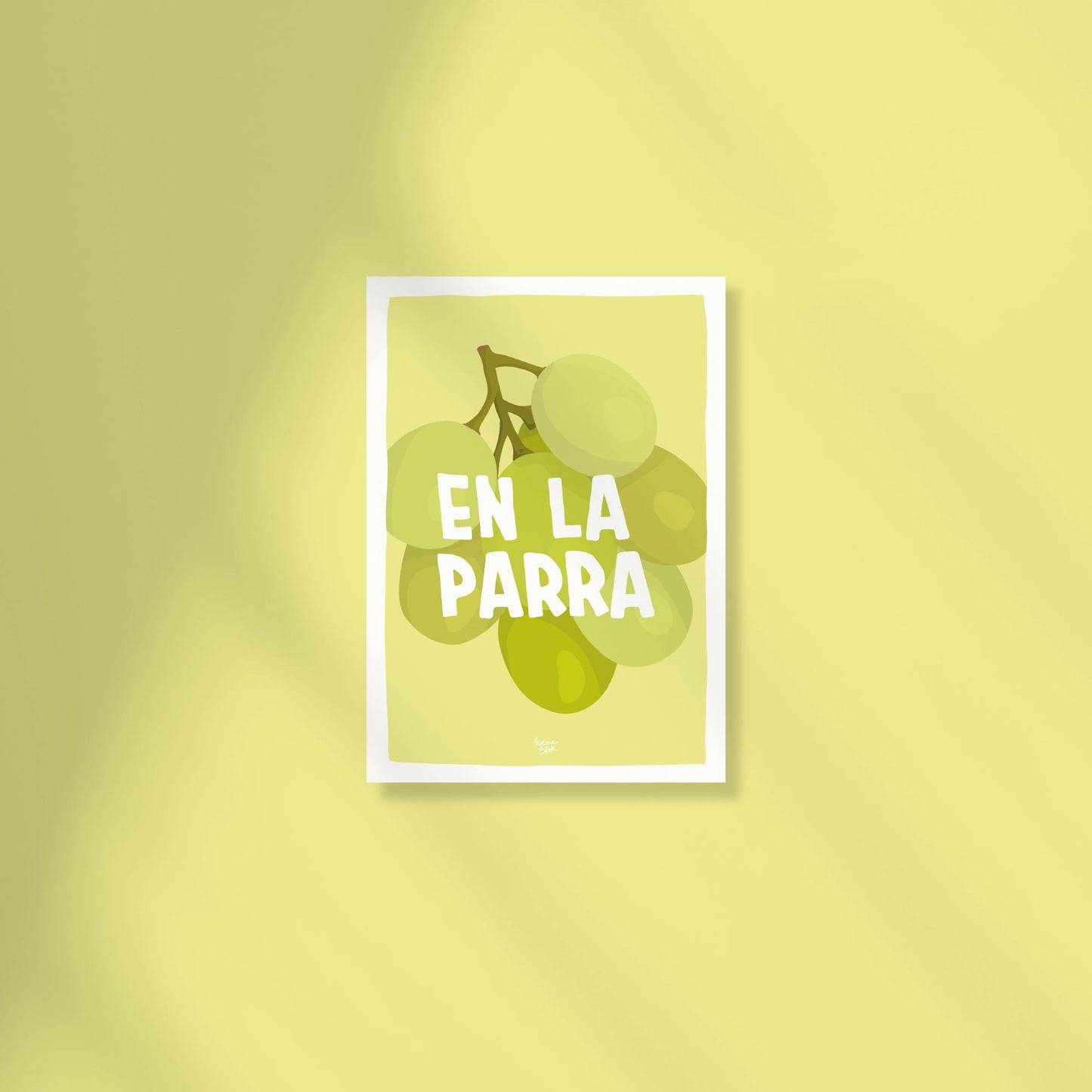 A vibrant A6 postcard with a light green background featuring a detailed digital illustration of a bunch of green grapes with the text "en la parra" written in a modern, casual font above the fruit by normablok.