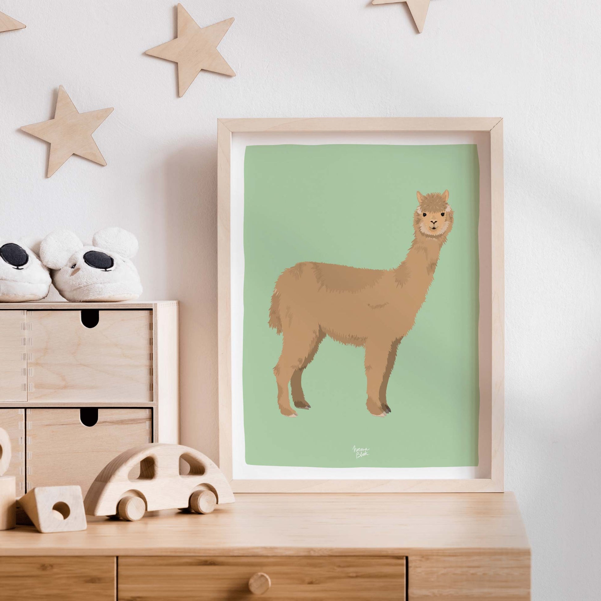The alpaca print styled in a charming nursery on a wooden dresser, surrounded by wooden toys and wall-mounted stars. This set-up highlights how the soft texture of the alpaca creates a playful, warm, and inviting environment for children.