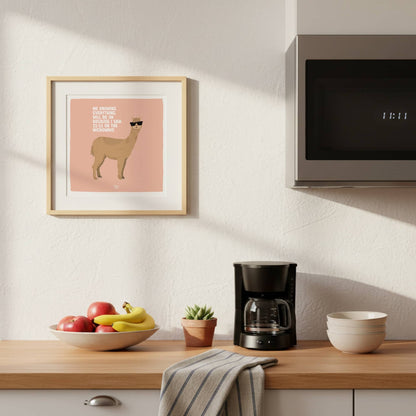 The square format layout of the alpaca print with the English text, beautifully framed and hanging on a contemporary kitchen wall. This location adds an extra layer of humor right next to where the microwave action actually happens.