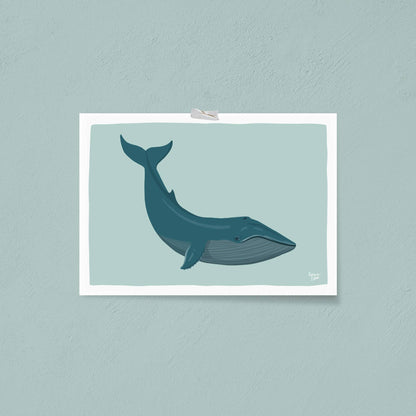 The unframed blue whale art print attached directly to a vibrant blue wall using colorful decorative washi tape. This playful and creative display option demonstrates a frame-free way to personalize a bedroom or studio space.