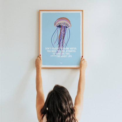 A lifestyle shot of a woman holding up a framed A3 size print to showcase its scale and visual impact in a real space.