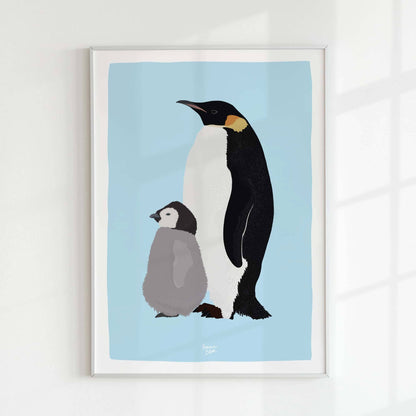 Emperor penguin print in a minimalist white frame on a white wall, illuminated by natural light from a window. Elegant home decor style.