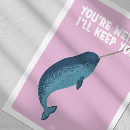 Close-up top-down flat lay focusing on the narwhal illustration and its playful horn detail against a light lilac background by Normablok.