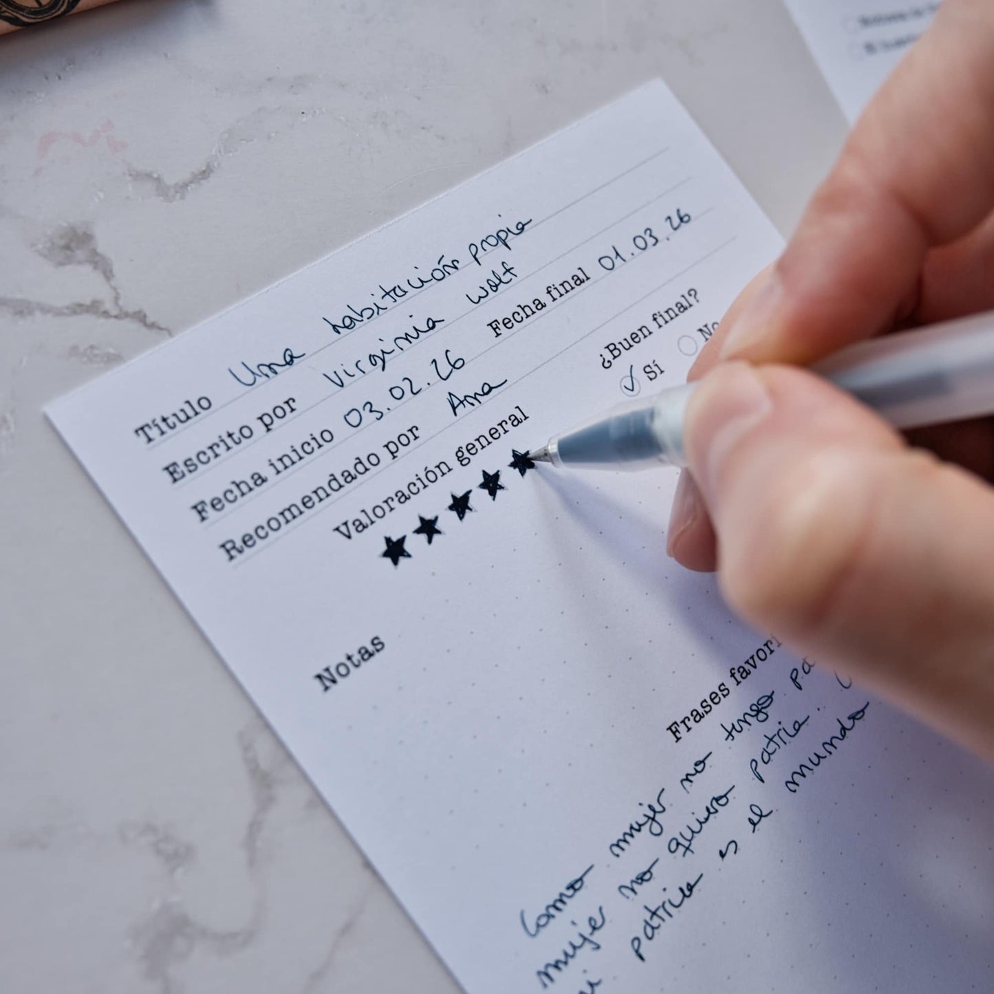 Four different reading log cards spread out on a desk, showing both the illustrated fronts and the functional tracking backs by Normablok.