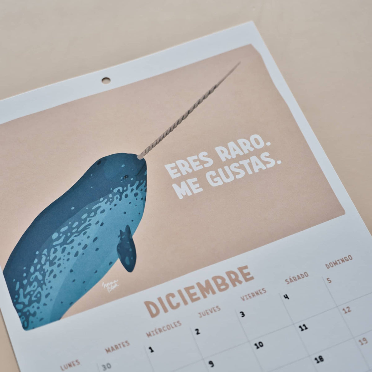 Página de diciembre del calendario 2027 de Normablok con un narval y la frase eres raro me gustas.