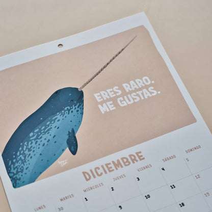 Página de diciembre del calendario 2027 de Normablok con un narval y la frase eres raro me gustas.