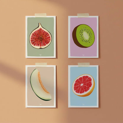 Four A6 fruit postcards hung creatively with washi tape on a warm terracotta-colored wall. This modern kitchen gallery shows how the figurative illustrations of fig, kiwi, melon, and grapefruit can brighten any space, room, or office. By normablok.