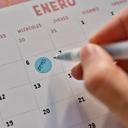 El calendario incluye pegatinas redondas para marcar festivos y fechas señaladas.