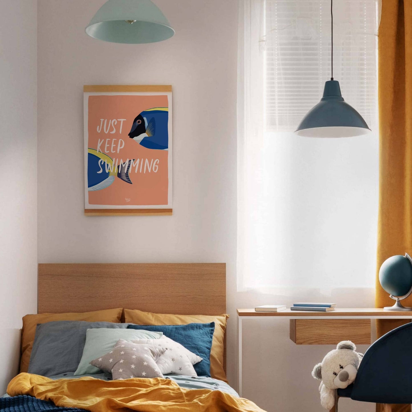 The coral "Just Keep Swimming" fish art print in a modern frame, hanging centered above the headboard of a bed in a bright kids' bedroom with clean white walls. The bedding features a mix of blue and yellow tones, creating a vibrant, fresh, and modern color contrast with the artwork.