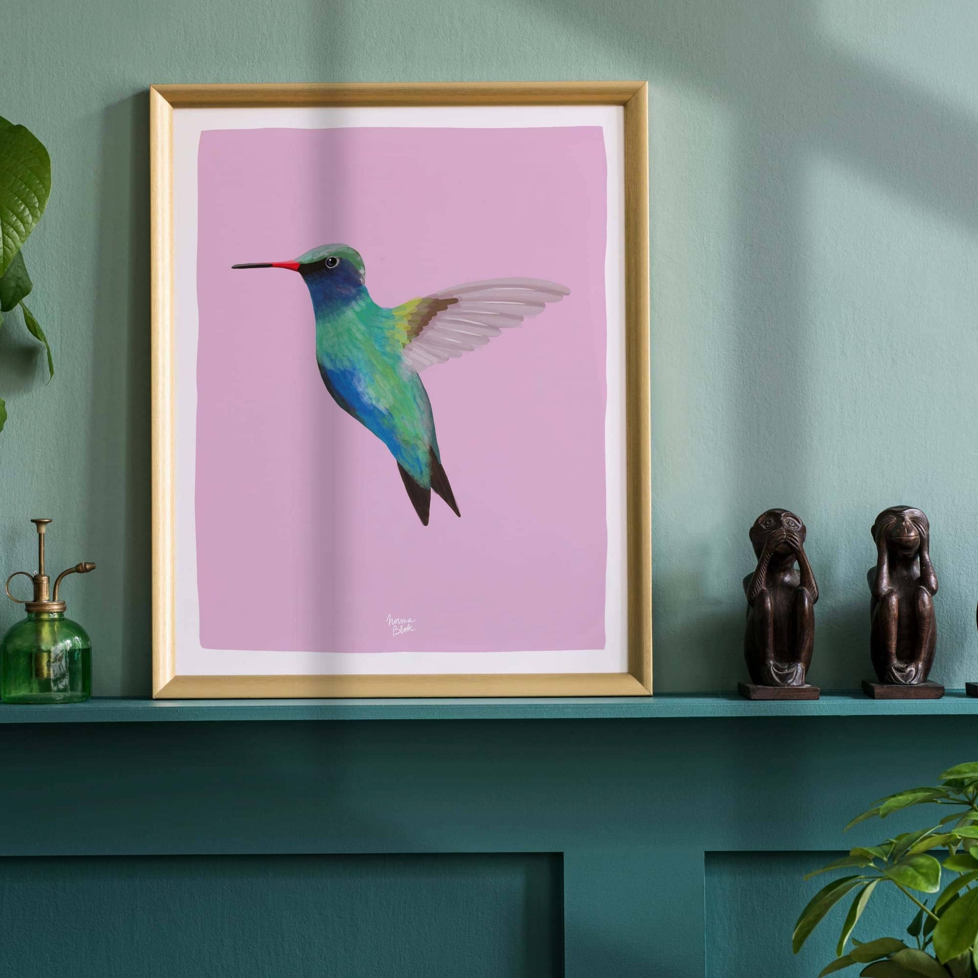 La lámina del colibrí enmarcada sobre una repisa turquesa dentro de una habitación con paredes turquesas claras. Este entorno monocromático y atrevido hace resaltar el fondo violeta de la ilustración, creando una decoración de dormitorio infantil muy moderna y cohesionada.