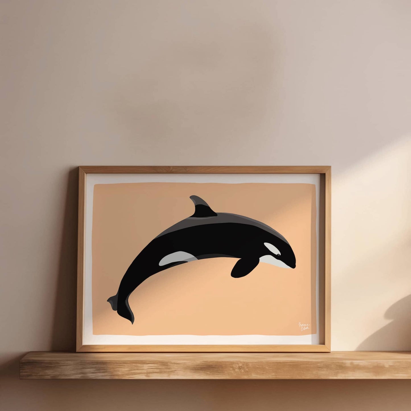 Orca art print in a warm wooden frame, styled on a bookshelf next to some plants, showing a cozy and modern interior design setup.
