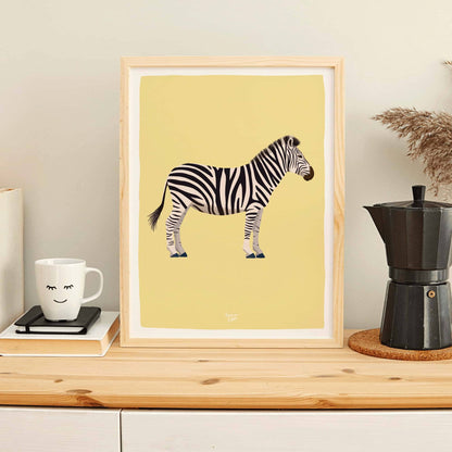 The zebra art print in a light wood frame leaning against the wall on a coffee station, next to a steaming mug and a classic Italian moka pot. This cozy, lifestyle setting shows how versatile the print is outside of nurseries, bringing a fun touch to a home coffee corner.

Castellano Alt Text: La lámina de la cebra en un marco de madera clara apoyada contra l