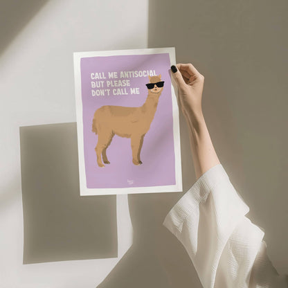 A hand holding the A4 size alpaca art print against a clean white background with a soft wall shadow by Normablok.