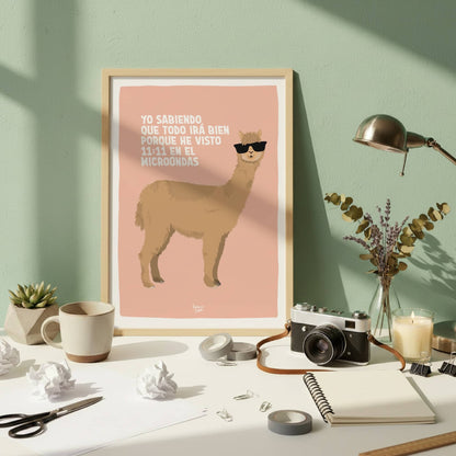La lámina de la alpaca en un marco de madera natural apoyada en una pared verde oscura. Está sobre un escritorio desordenado con libretas y bolis, mostrando cómo este diseño de afirmación caótica encaja perfectamente en un espacio de trabajo real, ocupado y del día a día.