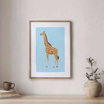 Giraffe illustration showcased in a sophisticated dark wood frame on an entryway console. Styled with a green plant and books, this home styling demonstrates how professional wildlife wall art elevates the elegance and design of your home entrance.