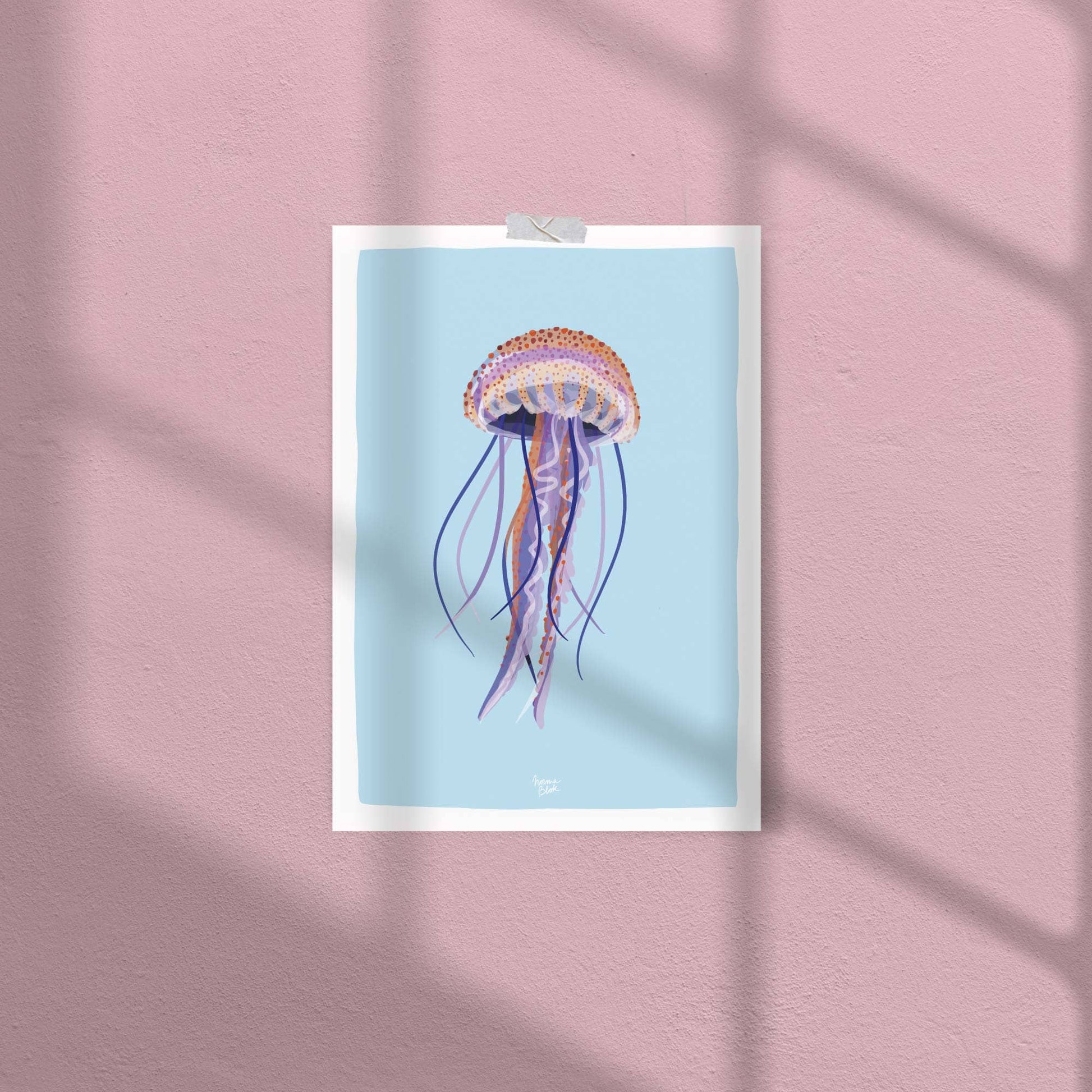 A close-up of the jellyfish art print attached to a soft pink wall with clear tape. This casual, no-frame display highlights the print's versatility and how the light blue background creates a cool contrast against the warm pink wall.