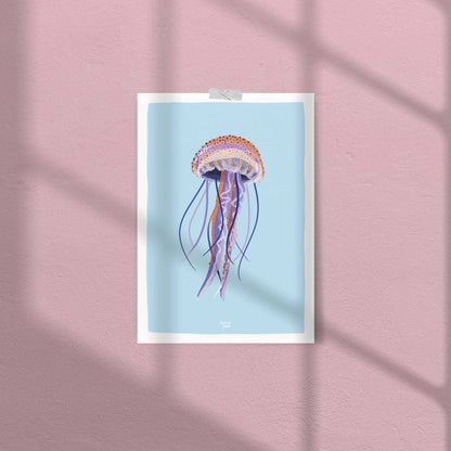 A close-up of the jellyfish art print attached to a soft pink wall with clear tape. This casual, no-frame display highlights the print's versatility and how the light blue background creates a cool contrast against the warm pink wall.