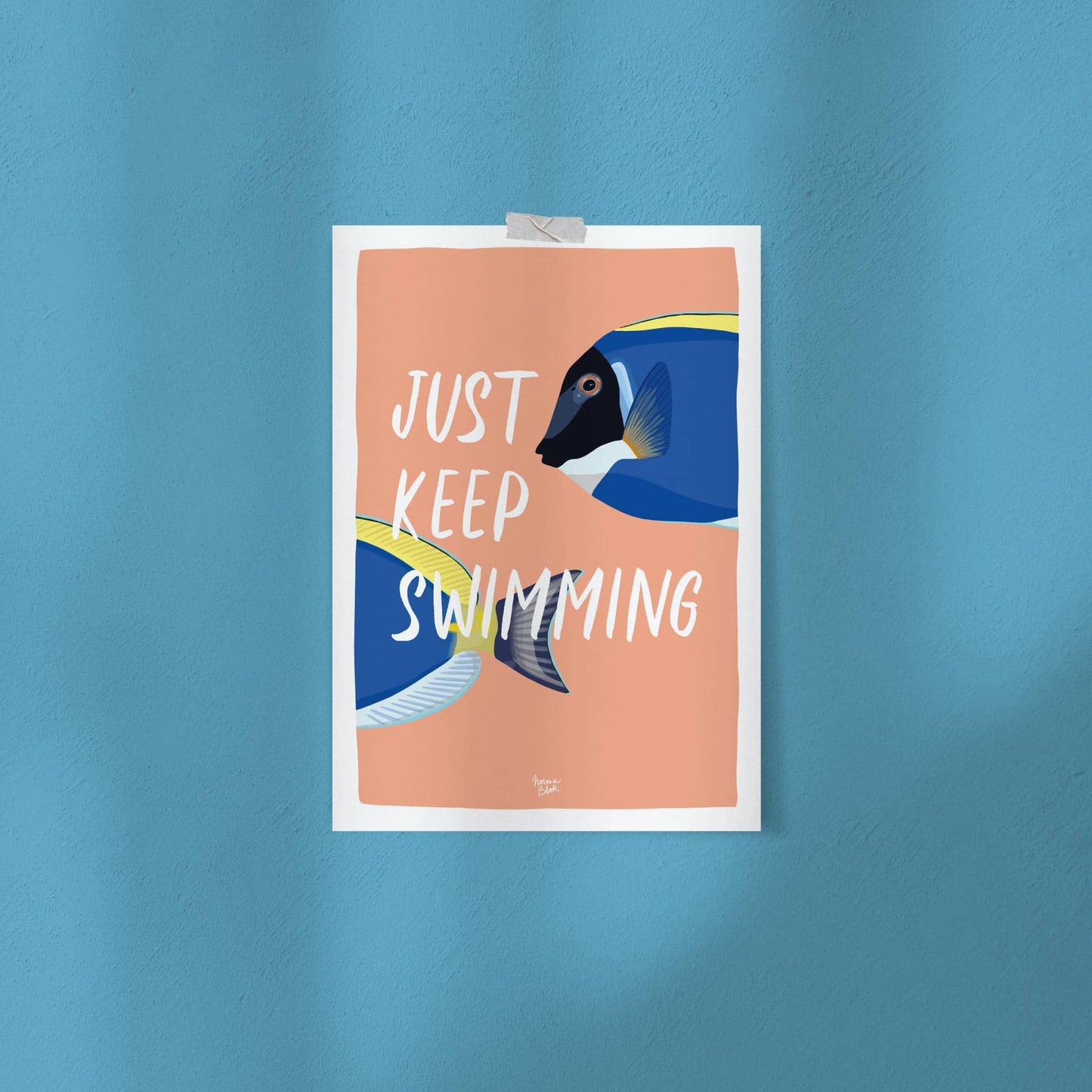 The funny surgeonfish digital illustration attached directly to a studio wall using simple pieces of colorful washi tape. This shot demonstrates an easy, casual, and frames-free way to style the art print in a modern office setup or apartment.