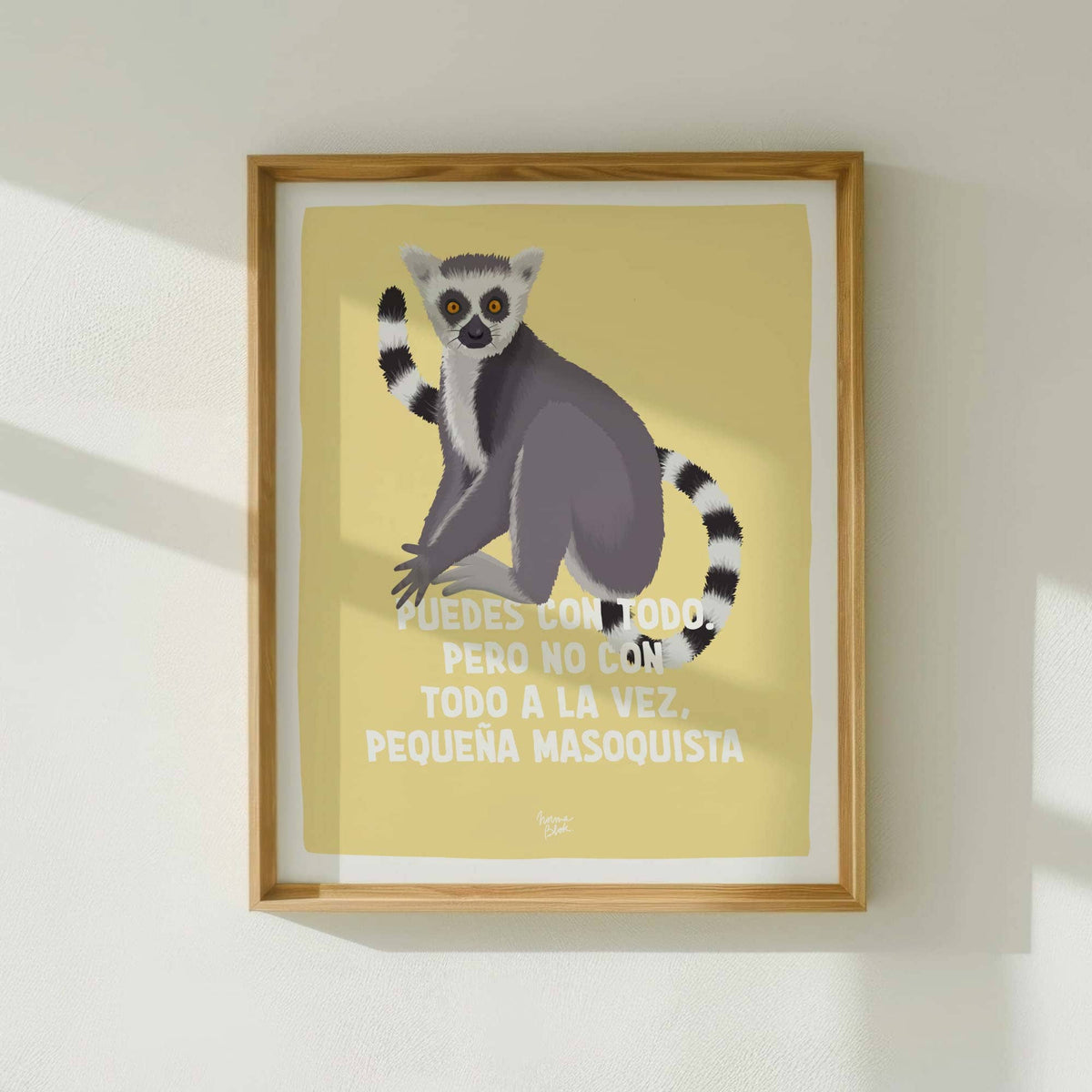 Lámina decorativa del lémur enmarcada en madera clara colgada en pared blanca con luz natural de ventana de Normablok.