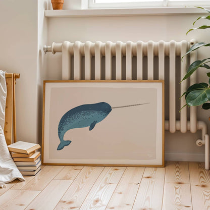 A large narwhal art print leaning against a wall in a room, positioned near a radiator, showing how to style art in a cozy, lived-in space.