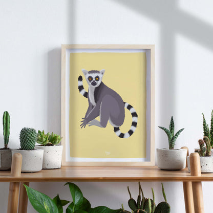 A framed lemur art print styled on a wooden table surrounded by several lush green houseplants. This interior scene shows how blending nature-inspired wildlife art with real botanical elements creates a cozy, fresh, and vibrant atmosphere in your home decor.