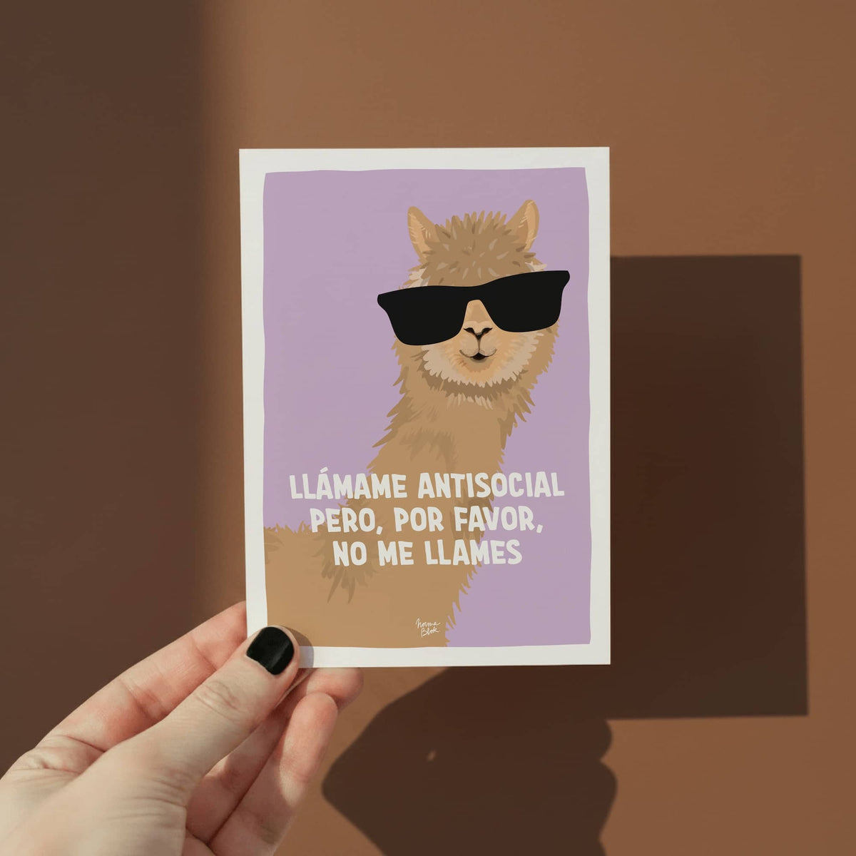 Mano sosteniendo una mini postal A6 de la alpaca para mostrar el tamaño real del producto.