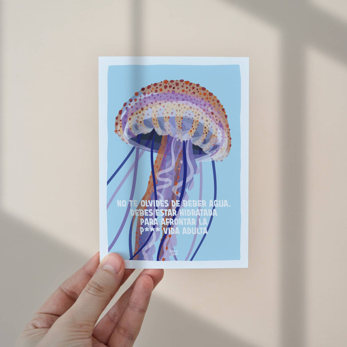 Una mano sosteniendo el mini print tamaño A6 para apreciar sus dimensiones reales, ideal para regalar o enviar por correo postal a esa amiga que lo necesita.