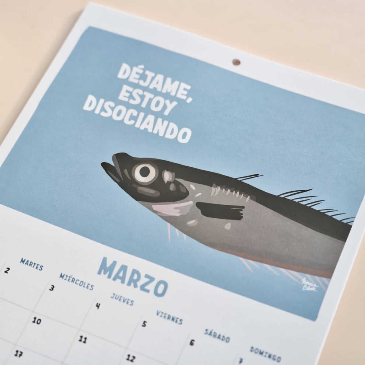 Página de marzo del calendario 2027 de Normablok con una sardina y la frase déjame estoy disociando.