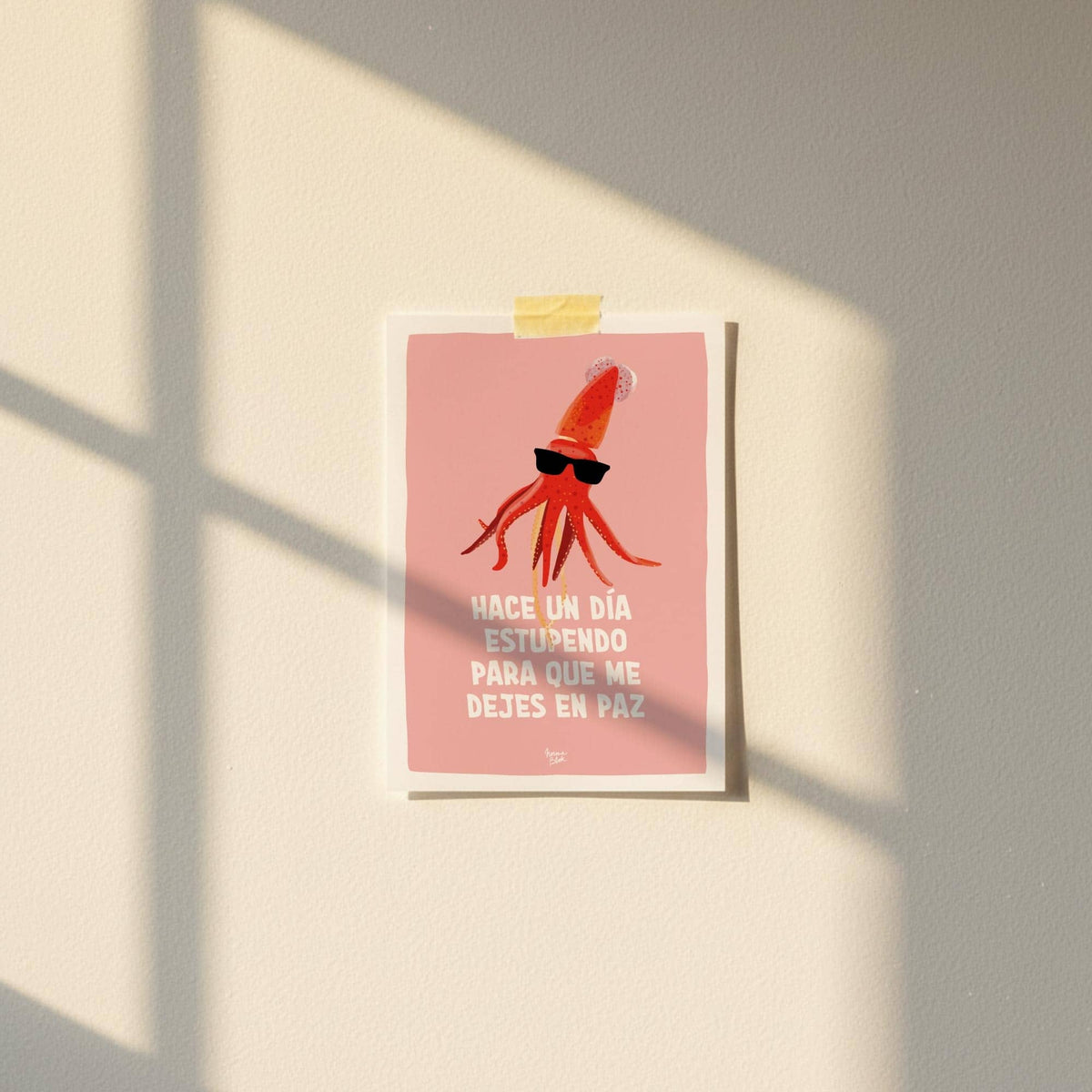 Mini lámina A6 con una ilustración de calamar fijada a la pared con cinta washi tape en una habitación.
