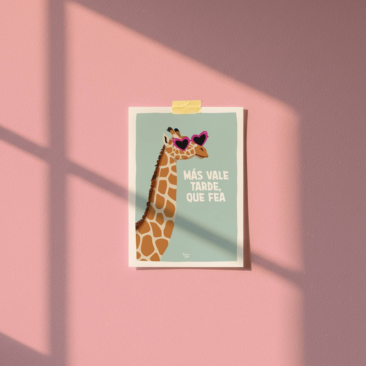 Mini lámina A6 con una ilustración de jirafa fijada a la pared con cinta washi tape en una habitación.