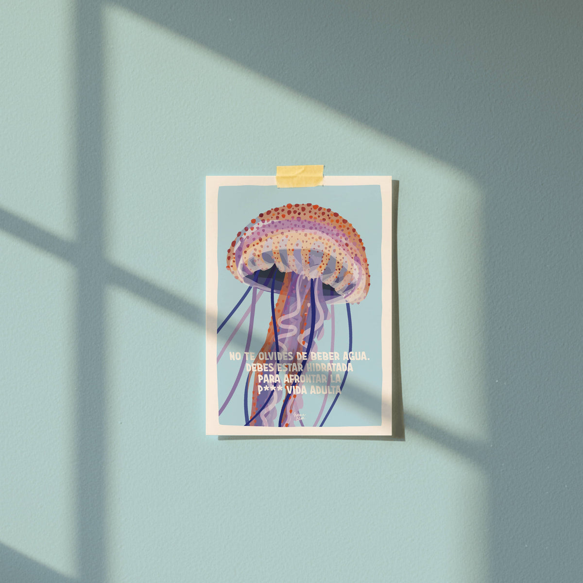 Postal de medusa colgada en una pared azul claro con celo, perfecta para ver cómo queda decorando cualquier rincón de tu habitación u oficina de forma original y cercana.