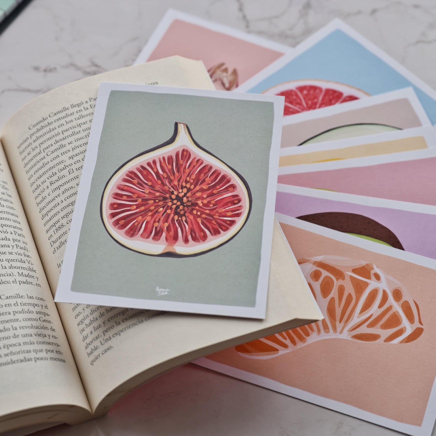 A detailed close-up of the fig-themed reading log card being used as a bookmark inside an open book. The image highlights the rich purple tones and textures of the fig illustration and the sturdy paper quality. You can see how the card fits perfectly between the pages, serving as a handy spot to jot down your favorite quotes and ratings. It’s the perfect companion for anyone who wants to remember exactly why they loved their last read. by normablok