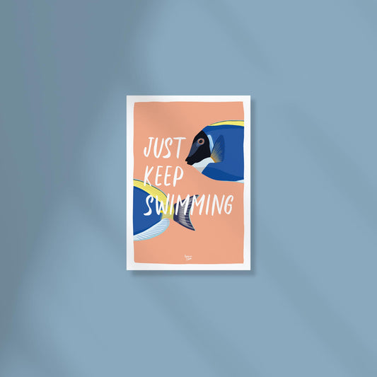 Postal A6 con fondo color coral y una ilustración digital de dos peces cirujano fluyendo por la imagen, con el texto "Just keep swimming" en el centro por normablok.
