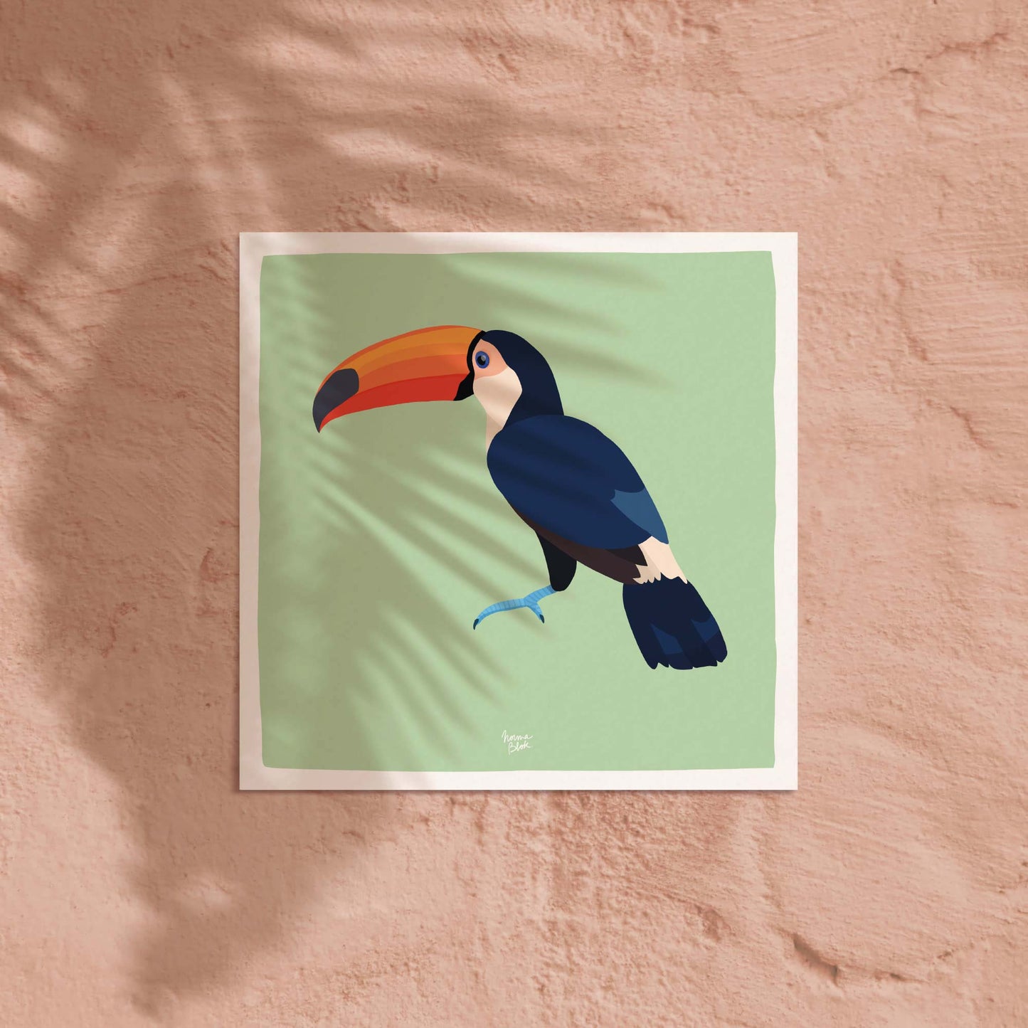 La lámina del tucán en formato cuadrado expuesta sobre una pared de color coral claro suave. El contraste entre la ilustración del pájaro tropical y el fondo cálido coral ofrece una idea decorativa alegre, moderna y de gran impacto para cualquier pared en un espacio infantil.