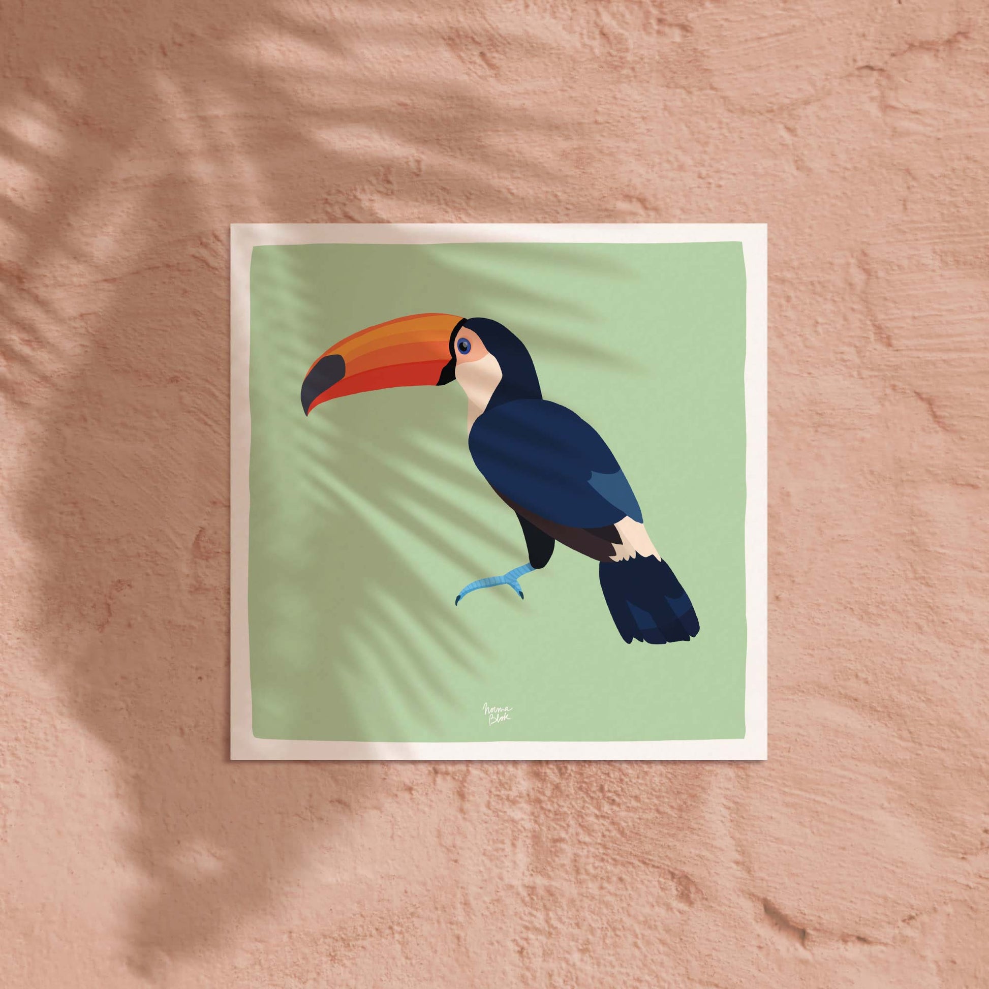 La lámina del tucán en formato cuadrado expuesta sobre una pared de color coral claro suave. El contraste entre la ilustración del pájaro tropical y el fondo cálido coral ofrece una idea decorativa alegre, moderna y de gran impacto para cualquier pared en un espacio infantil.
