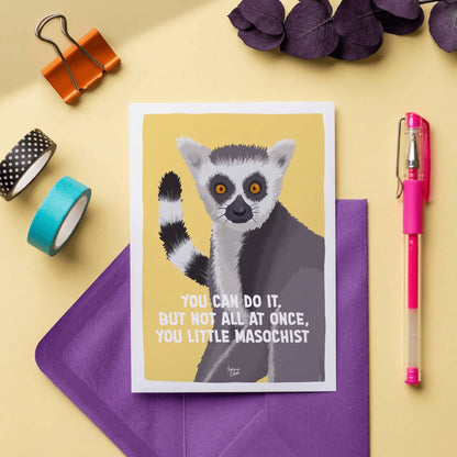 The A6 yellow lemur mini print titled "You can do it. But not all at once, you little masochist." displayed alongside a collection of colorful paper envelopes. The composition highlights how the vibrant yellow postcard pairs with bright pastel and bold envelopes, making it a cute and fun snail mail card or ready-to-send gift idea for a friend, showing the premium paper quality and crisp illustration details by Normablok.