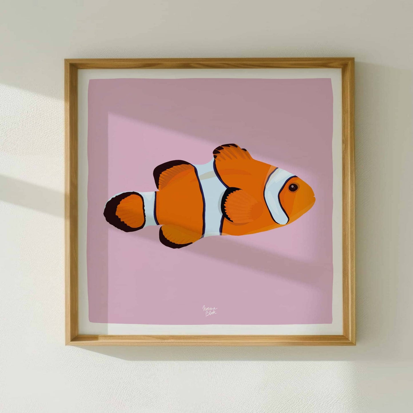 Illustration of a clownfish in a square format, within a wooden frame. Minimalist presentation that highlights the centered design and white border, ideal for wall compositions.