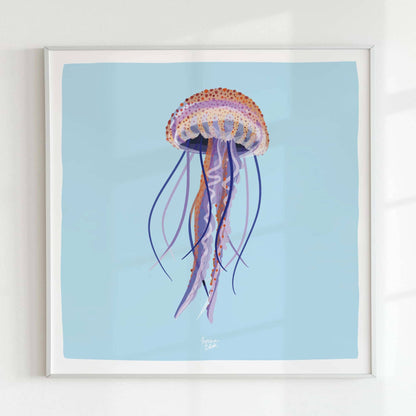 A minimalist shot of the square-format jellyfish print in a sleek white frame, mounted on a white wall. The monochromatic framing highlights the artwork’s transparency and colorful detail without any distractions.