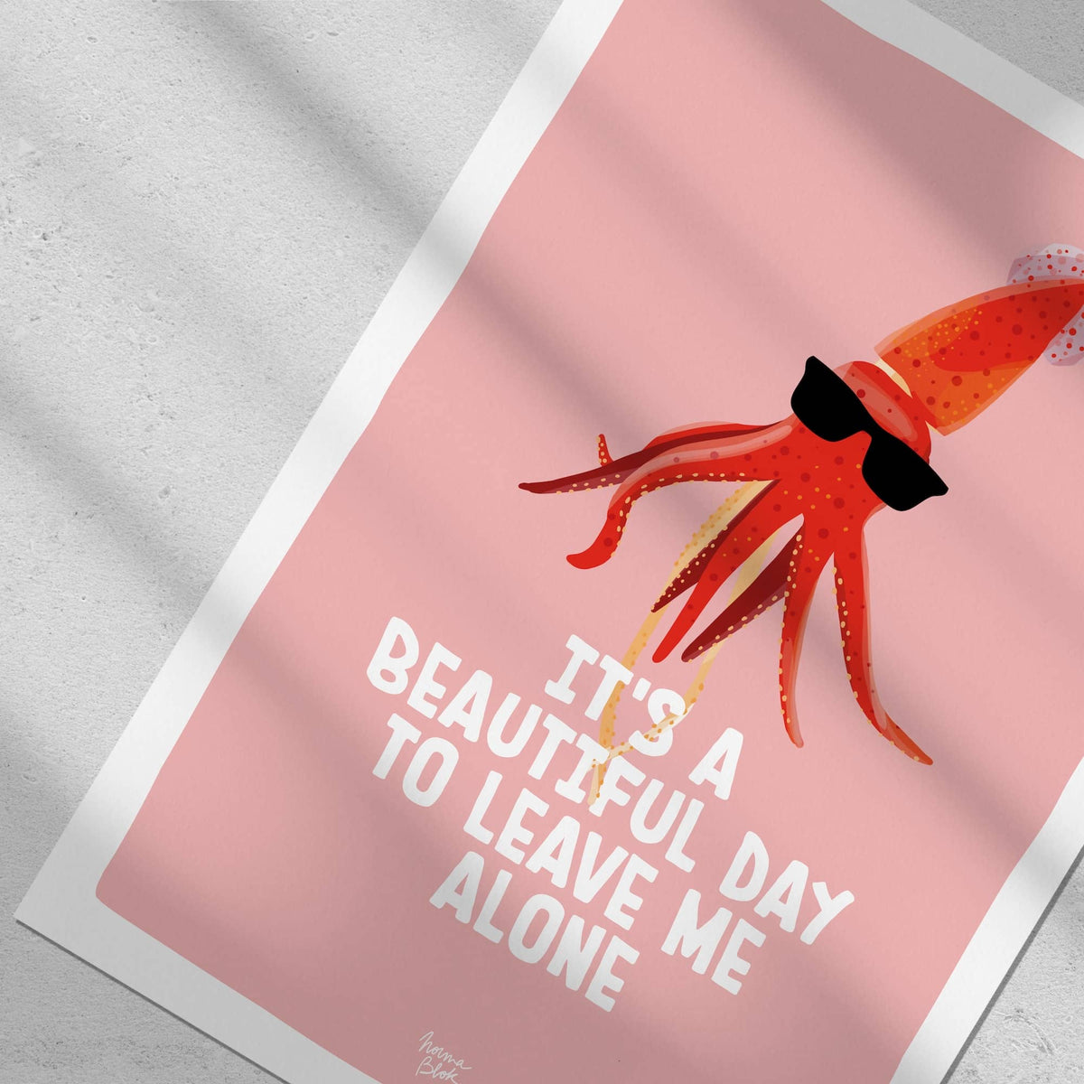 Close-up top-down flat lay focusing on the sunglasses-wearing squid against a salmon-pink background in a Normablok art print.