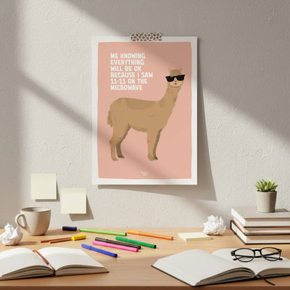 The light coral alpaca poster attached with colorful washi tape to a clean white wall. It hangs directly above a messy office desk with creative clutter, showing a casual, framework-free, and effortless style to decorate an authentic work-from-home setup.